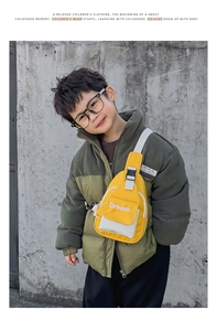 Detail of a bright yellow children's crossbody bag with Dream print worn by a young boy