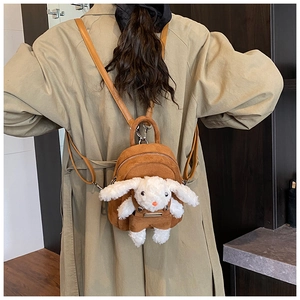 Close-up of a brown suede mini backpack featuring a 3D plush bunny and adjustable straps