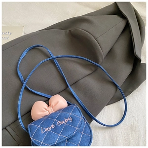 Détail du mini sac en denim bleu avec motif matelassé et nœud rose pour enfants