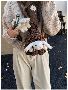 Detail of leopard print mini backpack with plush bunny and brown leather straps