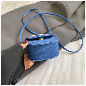Détail du mini sac bandoulière en denim bleu avec motifs matelassés et boucle dorée