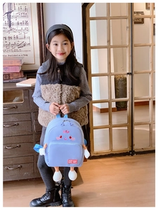Close-up of light blue cartoon backpack with cute facial design and 3D plush limbs