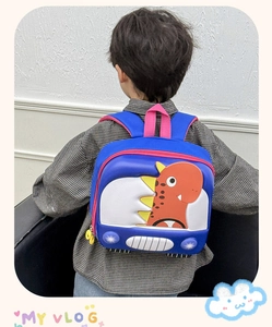 Rear view of child wearing blue dinosaur-themed hardshell backpack with red 3D spikes