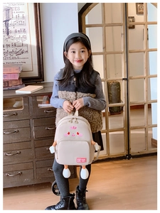 Detailed view of kids cartoon backpack featuring 3D legs and a trendy printed front pocket