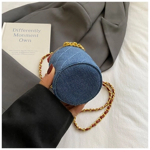 Detailaufnahme der gesteppten Denim-Beuteltasche mit Goldkette und rundem Boden