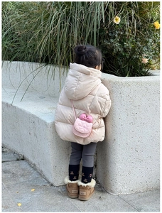 Petit sac bandoulière matelassé rose avec nœud et broderie porté par un mannequin enfant