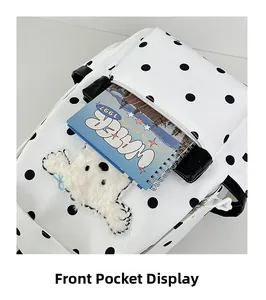 Détail de la poche avant du sac à dos à pois avec peluche animalière et nœud bleu