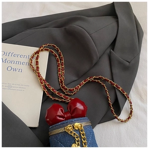 Detailansicht der Jeans-Miniband mit roter Schleife und goldener Ketten-Schultergurt