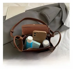 Interior view of brown pebble leather bag showing storage space for phone and makeup