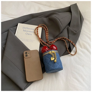 Detail der Mini-Jeanstasche mit roter Schleife, Steppmuster und goldener Kette