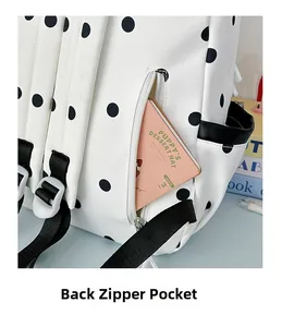 Détail d'un sac à dos blanc à pois montrant la poche arrière antivol avec fermeture