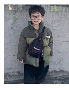 Detail view of child's black canvas chest bag featuring white Dream letter printing