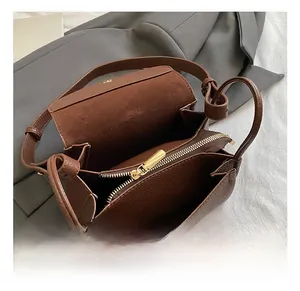 Interior detail of brown pebble leather bag showing gold zipper and spacious compartment