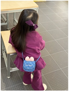 Détail d'un mini sac bandoulière en denim avec motif matelassé, nœud rose et pince à cheveux