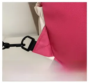 Dettaglio ravvicinato del tessuto rosa con cuciture rinforzate e gancio nero rimovibile