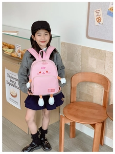 Detailed view of pink cartoon backpack featuring 3D character design on a child model