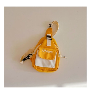 Detail of children's yellow chest bag showing adjustable strap and Dream embroidery
