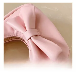 Close-up of pink PU leather child handbag featuring big bow and gold zipper detail