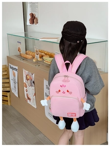 Detail of pink cartoon schoolbag with cute 3D plush arms and TREND ONE woven label