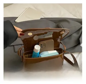 Interior view of brown patent leather square bag showing daily storage capacity and magnetic flap