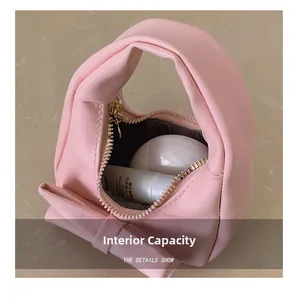 Interior capacity view of pink bow handbag showing storage for small skincare bottles