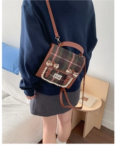 Close-up of vintage plaid backpack featuring lace trim and handmade bow details