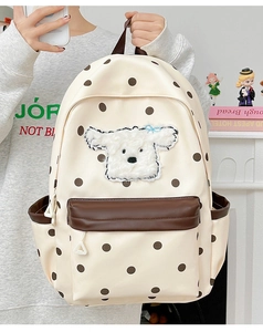 Détail d'un sac à dos en toile avec adorable écusson chien peluche et motifs à pois