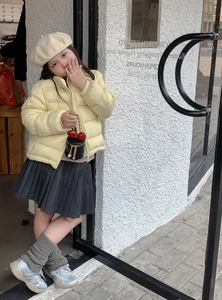 Detail einer gesteppten Box-Tasche mit roter Schleife und Kette zu einem Outfit