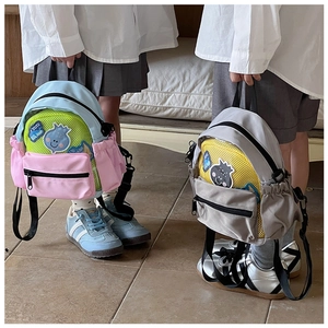 Dettaglio di zaini per bambini color-block con rete traspirante e toppe a fumetti