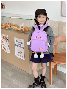 Detail of pink cartoon backpack featuring 3D embroidered character and durable fabric