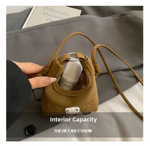 Detail showing internal capacity of brown bear print crossbody bag for small children