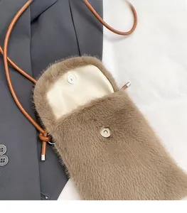 Detail der braunen Plüschtasche mit magnetischem silbernem Metallverschluss und Lederriemen