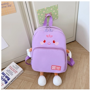 Close-up of a lavender cartoon backpack with cute facial embroidery on a wooden floor