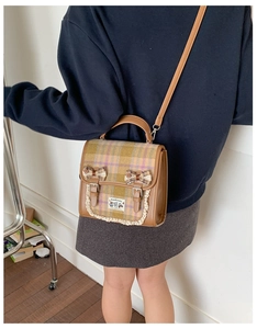 Detail of plaid JK style crossbody bag with lace trim and handmade animal patch