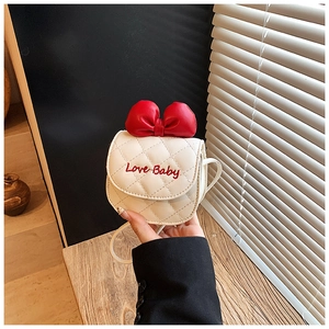Détail du mini sac matelassé blanc avec un nœud rouge et une broderie Love Baby élégante