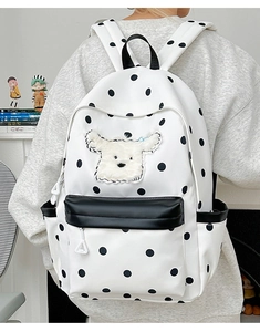Détail du sac à dos blanc à pois avec patch chiot en peluche et bretelles matelassées