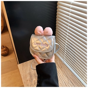 Détail du mini sac bandoulière argenté matelassé avec nœud rose et broderie élégante