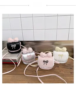 Selection of girls' mini bow crossbody bags in black, silver, pink, and white leather