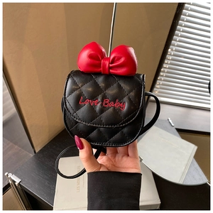 Détail d'un mini sac matelassé noir avec nœud rouge et broderie Love Baby pour enfant