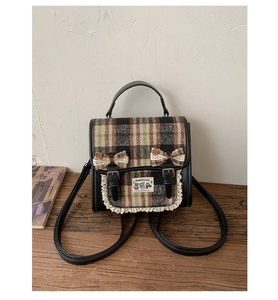 Detailed view of the plaid backpack with bow decorations and elegant lace trim edges
