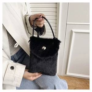 Detailansicht der schwarzen Kunstpelz-Minihandtasche mit silberner Schnalle und Ledergriff