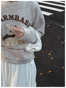 Street style shot of a mini white handbag featuring a bow design for little girls