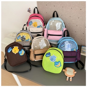 Dettaglio di mini zaini per bambini colorati con tasche in PVC e ricami a cartoni animati