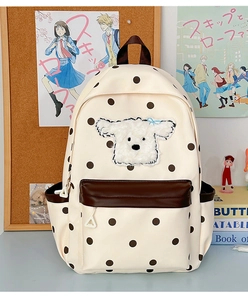 Détail du sac d'école beige à pois avec patch chien peluche et poche en cuir
