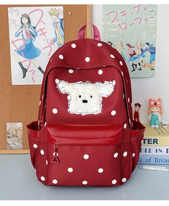 Vue détaillée du sac à dos rouge à pois avec patch chiot en peluche et poches latérales