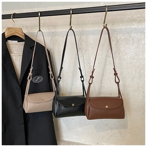 Detail of lychee pattern PU leather crossbody bags with gold circular metal buckles