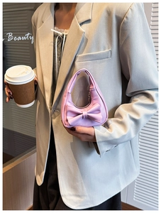 Detail of pink bow handbag for girls held by a model in a lifestyle fashion setting