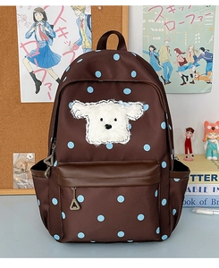 Détail d'un écusson chiot en peluche sur sac à dos marron à pois pour enfants