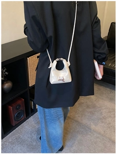 Mini cream crossbody bag with cute 3D teddy bear patch shown on a person