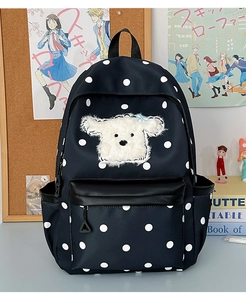 Détail d'un sac à dos bleu marine à pois avec un joli écusson brodé de chiot blanc